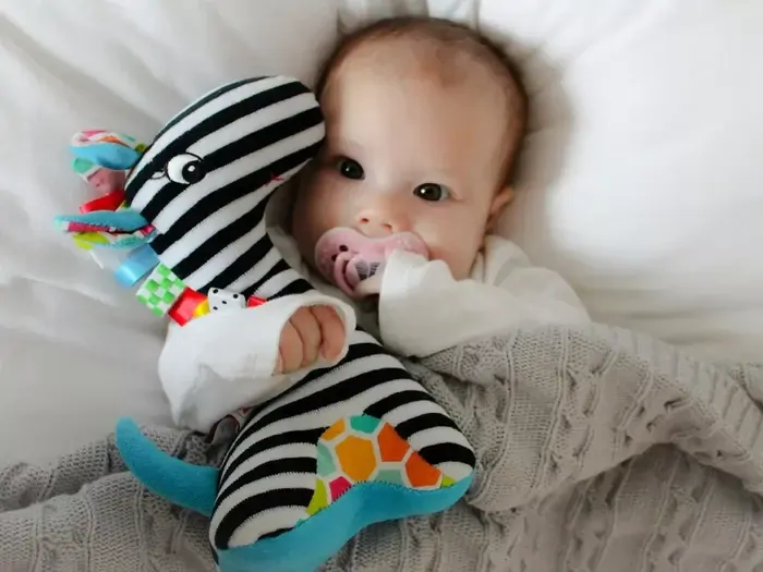 Mom´s Care Edukační hračka s chrastítkem - pruhovaná žirafa